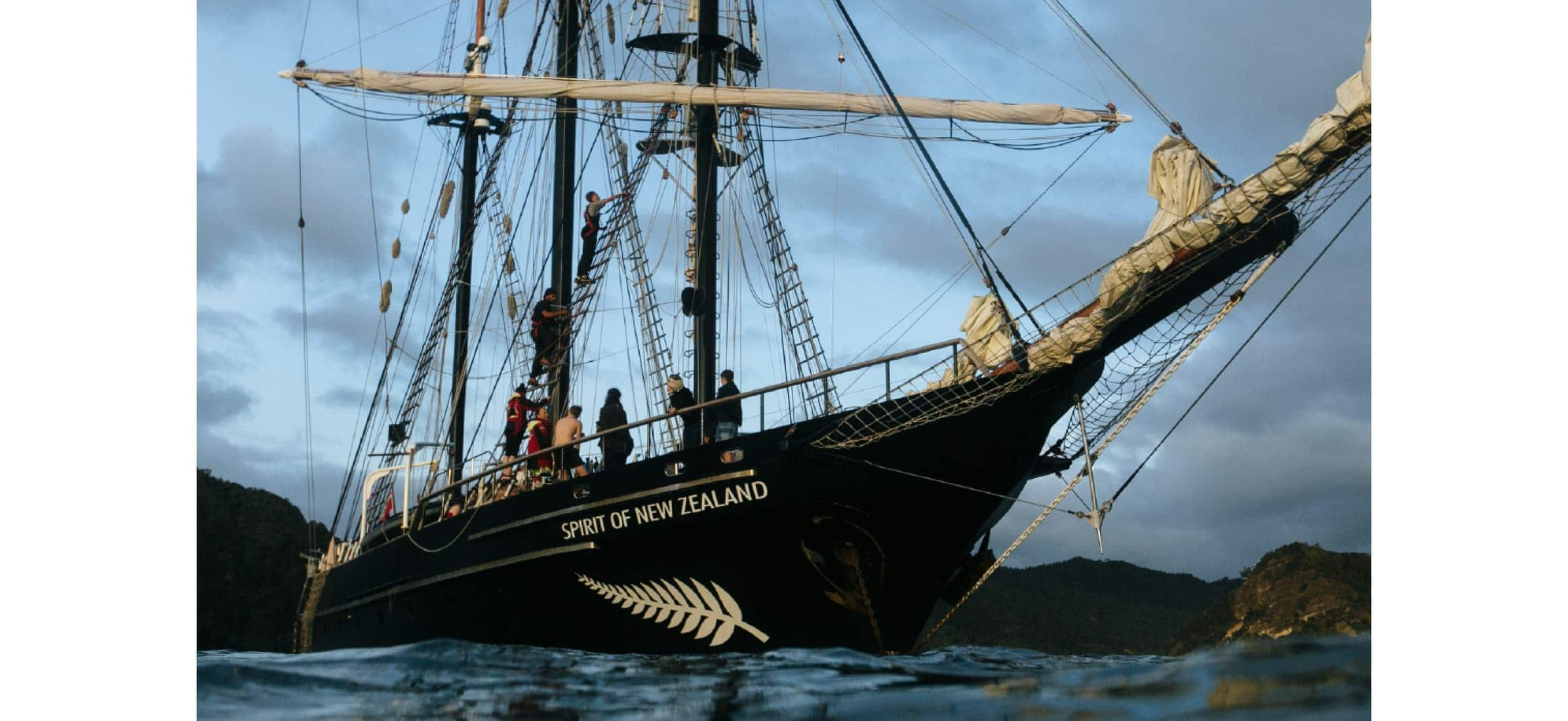 A small group of people outside on the deck of the Spirit of Adventure yacht